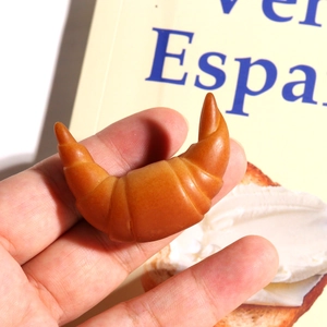 Dettaglio macro di un mini croissant in resina che mostra una consistenza realistica