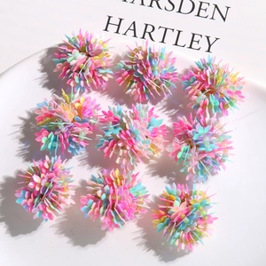 Colorful floral resin sequins for DIY earrings and hair accessories on a white plate