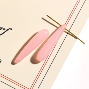 Detail view of pink translucent water drop pendant with golden T-pin for DIY earrings