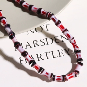 Macro shot of bamboo-shaped glass beads with red, white and black gradient textures
