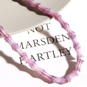 Detailed view of bamboo-shaped purple and white millefiori glass beads for DIY jewelry