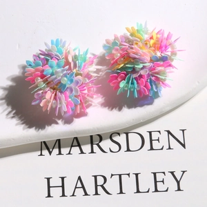 Macro shot of colorful woven acrylic flower earrings with 3D dopamine style effect