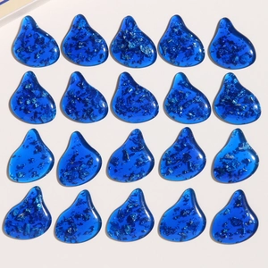 Macro view of blue water-drop resin charms with silver foil for DIY jewelry making