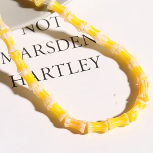 Detailed view of yellow and white Millefiori lampwork bamboo shape beads for jewelry