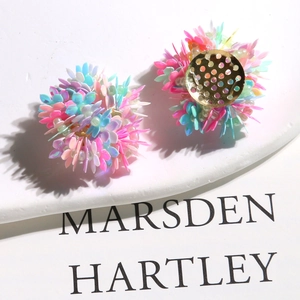 Macro detail of colorful sequin flower earrings with gold-plated metal base plates
