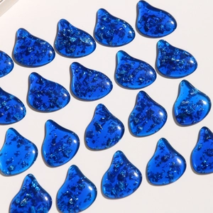 Deep blue teardrop resin pendants with silver foil glitter on white background