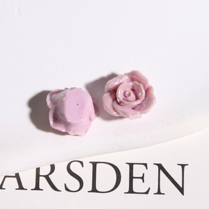 Macro view of pearlescent pink-purple resin rose flatback charms for DIY jewelry making