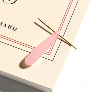 Detail of a pink translucent water drop pendant with gold metal pin for DIY jewelry