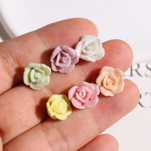 Close-up of 6 colorful pearlescent resin rose charms for DIY jewelry and crafts