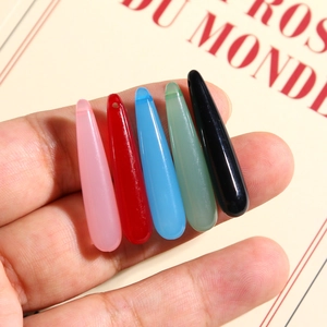 Detailed macro view of colorful translucent resin water drop pendants for DIY jewelry making