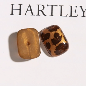 Detailopname van glitter luipaardprint en amber acryl oorbellen bedeltjes voor DIY sieraden