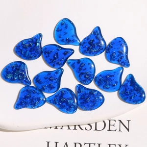 Macro detail of irregular blue resin charms with sparkling silver foil for DIY jewelry