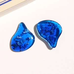 Macro shot of dark blue resin charms with silver foil for DIY jewelry making
