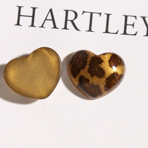 Macro-opname van glitter amber en luipaard acryl hart bedeltjes voor DIY sieraden
