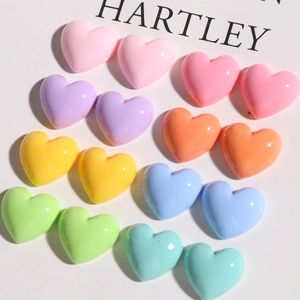 Perles en forme de cœur en résine macaron colorée avec finition brillante sur fond blanc