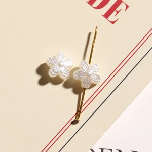 Macro detail of white pearl camellia flower beads with intricate petal textures for jewelry
