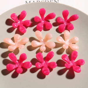 Top view of nine pearlescent resin tulip flower charms in pink and magenta tones