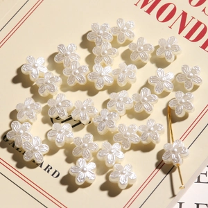 Vintage pearl ivory resin camellia flower beads for DIY jewelry making scattered on book