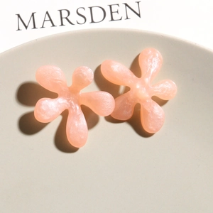 Macro view of pink tulip resin flower charms with a pearlescent finish and smooth petals