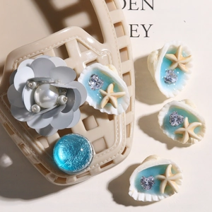 Detalle de adornos marinos para zapatos con conchas y estrellas de mar en zuecos beige