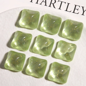 Macro shot of square glittery avocado green resin charms for DIY jewelry making