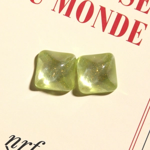 Macro shot of square avocado green resin studs with glitter inside for DIY jewelry