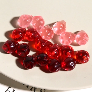 Dettaglio macro di ciondoli a fragola in resina traslucida per la creazione di gioielli
