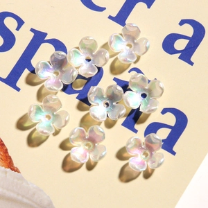 Macro shot of iridescent clover flower beads with shimmering pearl finish for DIY nails