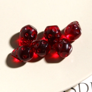 Macro di sei ciondoli a fragola in resina rossa traslucida con dettagliata trama superficiale