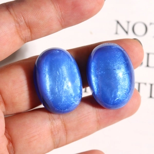 Close-up of royal blue glitter resin oval cabochons with sparkling starry texture