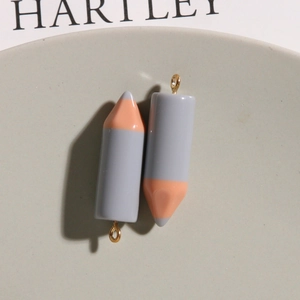 Macro shot of 3D resin pencil pendants in gray and pink for DIY jewelry making