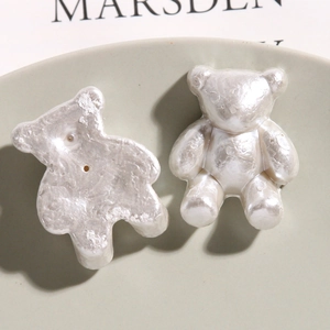 Macro shot of pearl white resin bear bead with glossy finish and flat back for DIY crafts