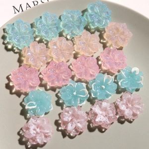 Macro shot of glittery resin camellia flower charms for DIY jewelry and hair accessories