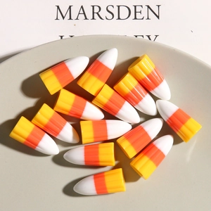 Vue détaillée des breloques DIY en résine candy corn aux couleurs vives jaune orange blanc