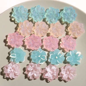 Detailed view of twenty colorful glitter resin flower charms for DIY hair accessories