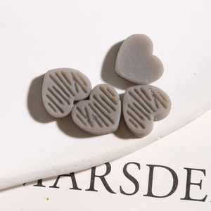 Detailweergave van grijze hars hartbedeltjes met textuur voor DIY sieraden maken hobby