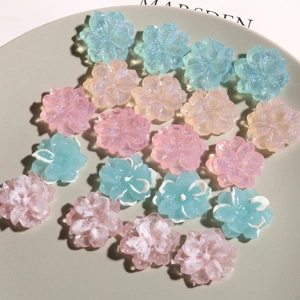 Macro detail of glittery resin camellia flower charms for DIY hair clip accessories