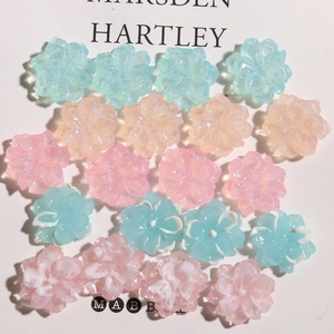 Macro detail of glitter resin camellia flower charms for DIY hair accessories and jewelry