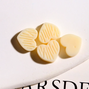 Detailopname van crème hartvormige harsbedeltjes met gestreepte textuur voor DIY-sieraden