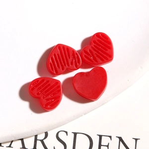 Macro-opname van rode hartvormige harsbedeltjes voor het maken van DIY-sieraden