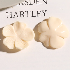 Macro shot of cream-colored resin flower charm with detailed petal texture