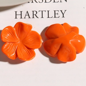 Macro shot of orange resin flower charms showing front petals and flat back details