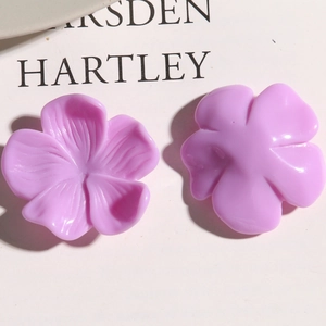 Macro shot of lilac resin flower charms showing detailed petal textures and smooth back