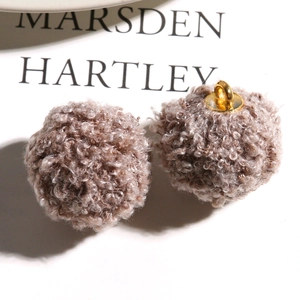 Macro shot of fluffy brown teddy faux fur charms with gold metal loops for DIY jewelry