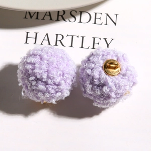 Close-up of fuzzy purple plush balls with metal shanks for DIY jewelry making