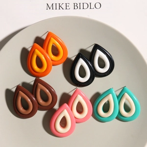 Detalle de pendientes de resina en forma de gota en cinco combinaciones de colores bitono