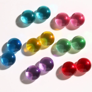 Detalle de cuentas de resina traslúcida de colores con purpurina para joyería DIY