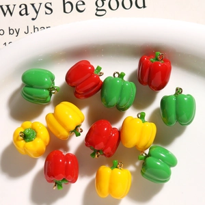Detail of colorful mini resin pepper charms with gold rings for DIY jewelry making