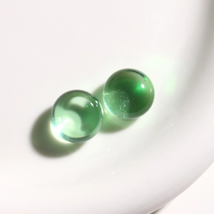 Vista macro de cabujones de resina verde esmeralda transparentes para joyería y artesanía