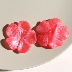 Makroaufnahme von Harzblumen-Anhängern mit orangefarbener Marmortextur für DIY-Schmuck